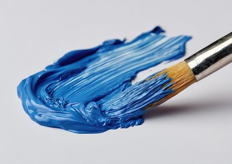 Close-up of a vibrant blue paint stroke on a light background, with a paintbrush
