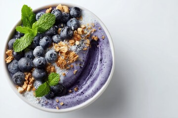 Vibrant layered smoothie bowl topped with fresh blueberries and granola