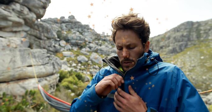 Feeling breeze, outdoor enthusiast zipping weatherproof technology jacket under hammock for warmth