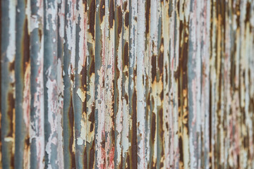 ペンキが剥がれて茶色く錆びた古いトタン板のクローズアップ。金属素材の背景