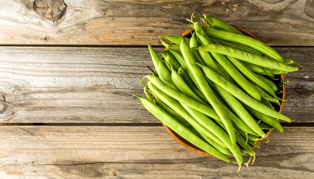 Fresh green beans in a wooden bowl on rustic wood