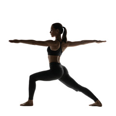 Obraz premium Silhouette of athletic woman in warrior two pose practicing yoga and wellness under low key lighting