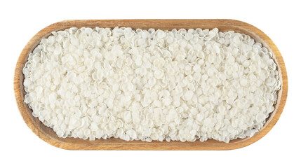 Rice flakes pile in wooden bowl isolated on white background, top view