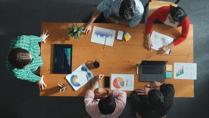 Top down view of manager holds tablet display increasing sales and placed on meeting table. Group of diverse business team clapping hands to celebrate successful product at meeting room Convocation.