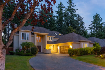 Two story stucco luxury house with big tree and nice landscape at night at Summer in Vancouver, Canada, North America. July 2025.