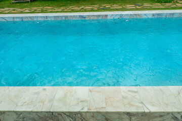 Empty swimming pool with sunbed and white umbrella in resort hotel for vacation leisure and white sand,resort neary sea and beach in summer.