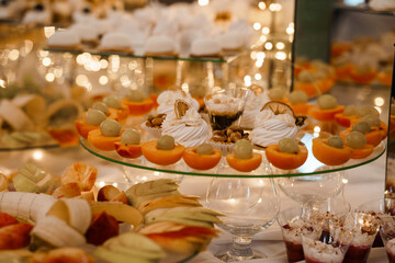 Elegant Wedding Dessert Table with Oranges, Cream Pastries, and Fruits, Warm Lighting, Celebration Feast, Luxury Event Styling, Golden Tones