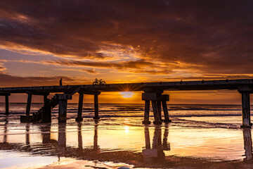 Obraz premium Butwani bridge and Malindi Pier area is a popular waterfront location known for stunning sunrises over the Indian Ocean. The pier is a concrete jetty that stretches about 400 meters into the ocean and