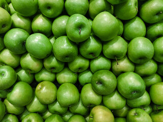 Fresh green apples stacked together, crisp and juicy fruits rich in fiber and vitamin C. Perfect for healthy eating, diet, vegan lifestyle, and natural food background concept