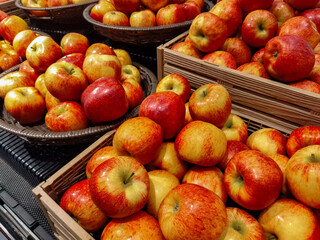 Fresh red and yellow apples stacked in wooden crates and wicker baskets at the store. Natural and juicy fruits, perfect for a healthy diet, vegetarian meals, or fresh seasonal harvest