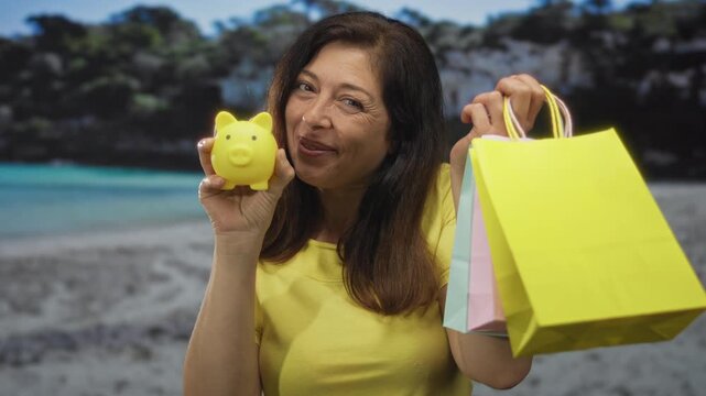 Woman holding bright yellow piggy bank and pastel shopping bags at sunlit sandy beach; savings optimism.
