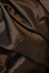 Fototapeta premium Textured brown fabric folds elegantly.