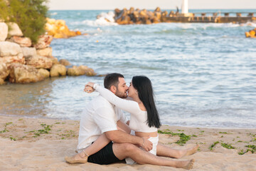 Fototapeta premium Beautiful young couple in love in summer at sea on the beach. Summer concept. husband and wife. groom and bride. love