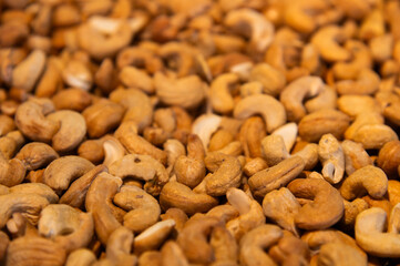 View of a pile of cashew nuts with full detail and texture. Close-up background of nuts, roasted peeled brown cashew
