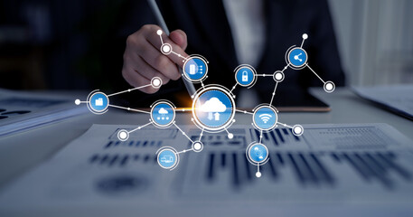 A business professional in a modern office setting examines data and cloud computing icons, illustrating the intersection of technology and analytics for business growth. Tessel