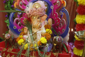 Ganapati festival celebration at home with a beautifully decorated Ganesh idol, flowers, lights, and traditional offerings, symbolizing devotion, prosperity, and cultural heritage in a festive atmosph