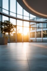 Fototapeta premium Modern office atrium with natural sunlight and large glass windows at sunset