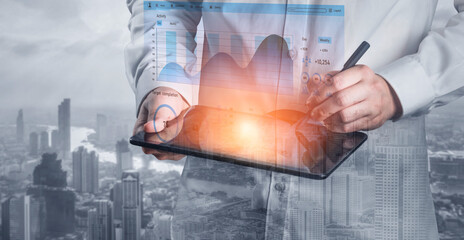 Business Professional Analyzing Data on Tablet with City Skyline Background and Graphical Interface Overlay Impute.