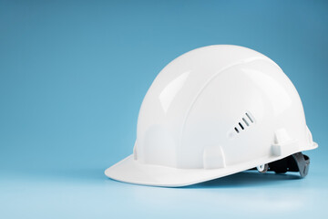 White safety helmet on a blue background with free space