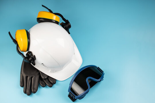 Yellow headphones with a white helmet and dark welding glasses on a blue background