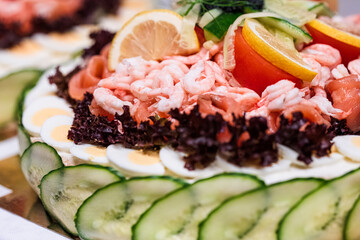Shrimp and egg sandwich cake with lemon and cucumber.