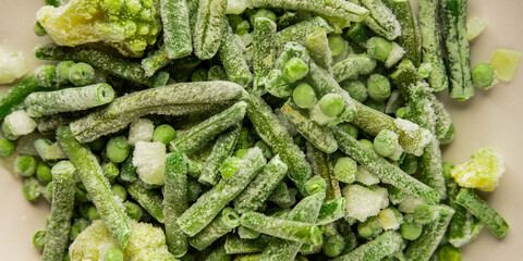 Frozen green vegetables green peas, broccoli, string beans, kohlrabi kale tasty snack fresh food background on the table rustic food top view copy space keto and paleo diet vegan and vegetarian food