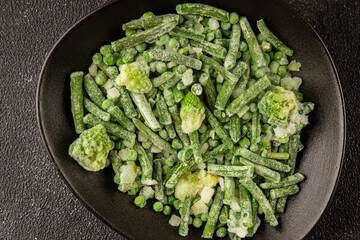 Frozen green vegetables green peas, broccoli, string beans, kohlrabi kale tasty snack fresh food background on the table rustic food top view copy space keto and paleo diet vegan and vegetarian food