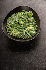 Frozen green vegetables green peas, broccoli, string beans, kohlrabi kale tasty snack fresh food background on the table rustic food top view copy space keto and paleo diet vegan and vegetarian food