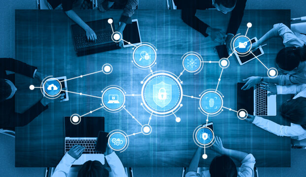 A diverse group of professionals gathers around a modern table with laptops and smartphones, collaborating on technology and data security concepts in a dynamic office setting. Tessel