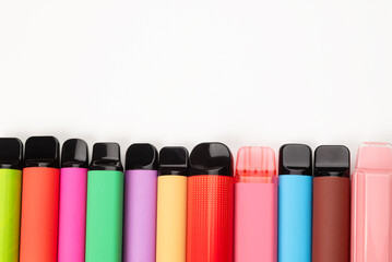 A set of colorful disposable electronic cigarettes of different shapes on a white background....