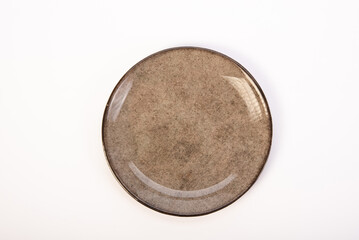 Beautiful ceramic plate placed on a white background, selective focus. Top view.