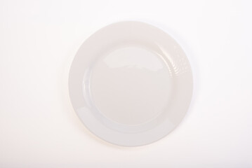 Beautiful ceramic plate placed on a white background, selective focus. Top view.