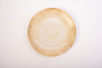 Beautiful ceramic plate placed on a white background, selective focus. Top view.