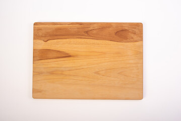 Beautiful wooden kitchen cutting board placed on a white background, selective focus. Top view.