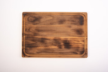 Beautiful wooden kitchen cutting board placed on a white background, selective focus. Top view.