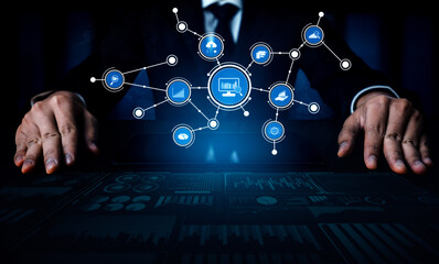 A businessman is focused on analyzing data visualizations displayed in a modern office. Digital symbols represent various aspects of global markets and technologies. Tessel