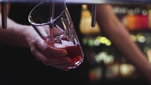 Bartender pouring craft beer cider in the glass from the crane, beer festival in a bar, barkeeper working in a pub, barman by the counter serving drinks and alcohol beverages on party in a night club