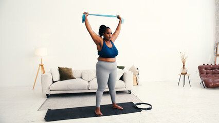 Plus size black woman does strength training with resistance band