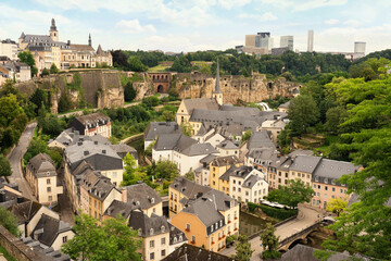 Luxembourg City, the capital of Luxembourg, features a dramatic old town built on cliffs, with historic architecture, fortress walls, and modern skyscrapers blending into lush green surrounding.