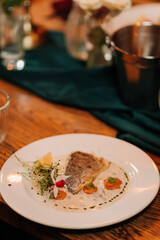 Elegant gourmet fish dish on festive table with romantic candlelight ambiance