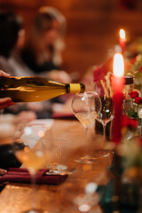 Close-up of white wine being poured into a glass at elegant candlelit dinner celebration