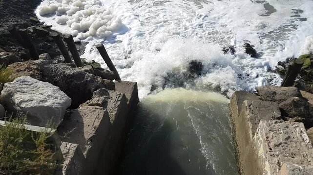 Torrents of water rush through floodgates in the Carboneros marshes, Chiclana de la Frontera, C&aacute;diz, Spain. A dynamic scene of nature, flow, and hydraulic infrastructure.