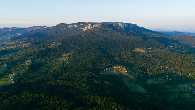Aerial landscape of Romanija mountain slopes with green valleys, villages, and forested ridges