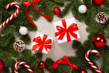 Festive Christmas tree branches with gift box on concrete background, top view
