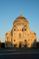 A stunning cathedral stands majestically at sunset, crowned with a beautiful golden dome