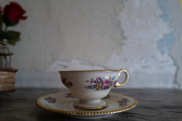 beautifully painted and designed art on a gold-rimmed tea cup and saucer dating back a couple of hundred years