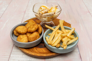 Fast-food style chicken nuggets, with their signature shape and extra crunchy coating, accompanied by sweet and sour sauce
