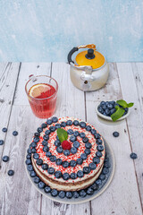 Individual Red Velvet Tartlets: sponge cake base in a metal ring, filled with blueberry mousse and Chantilly cream