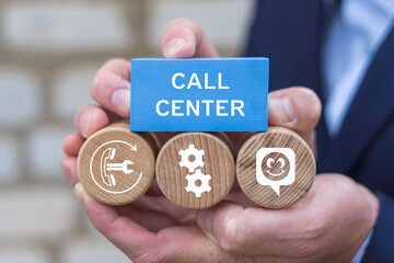 Call center 24-7 technical support customer service internet business concept. Business person holding blocks with icons sees the inscription CALL CENTER.