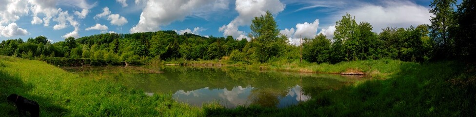 Beautiful panoramic view of the lake in the evening. Mirror reflection in the water. Panorama of a forest lake at dawn.